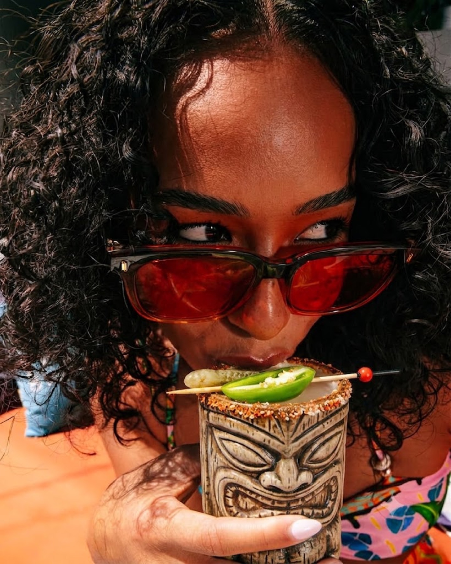 Guest sipping a spicy cocktail from a tiki mug